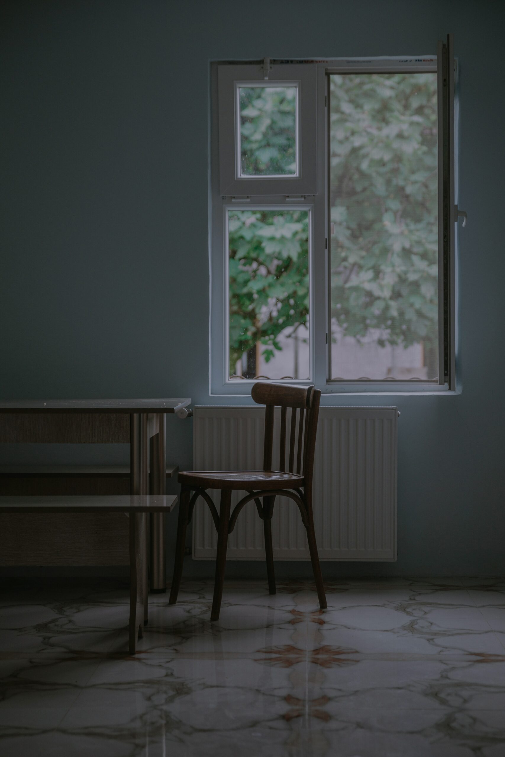 Empty chair beside a window in soft morning light