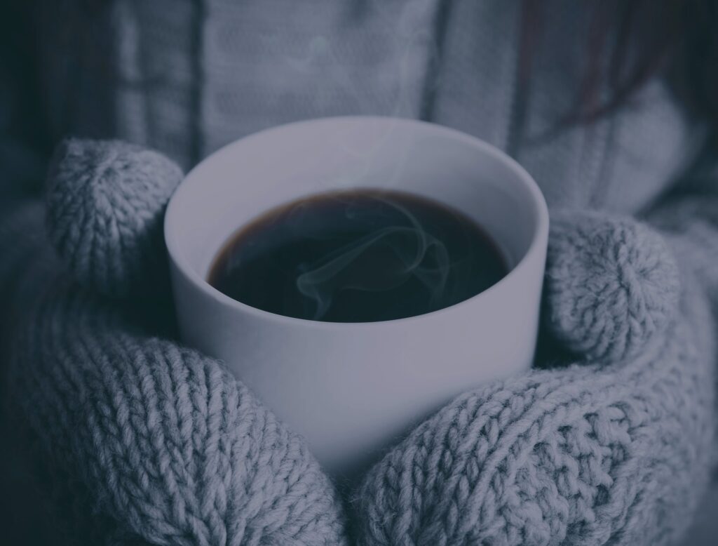 Hands cupped around a warm mug of coffee