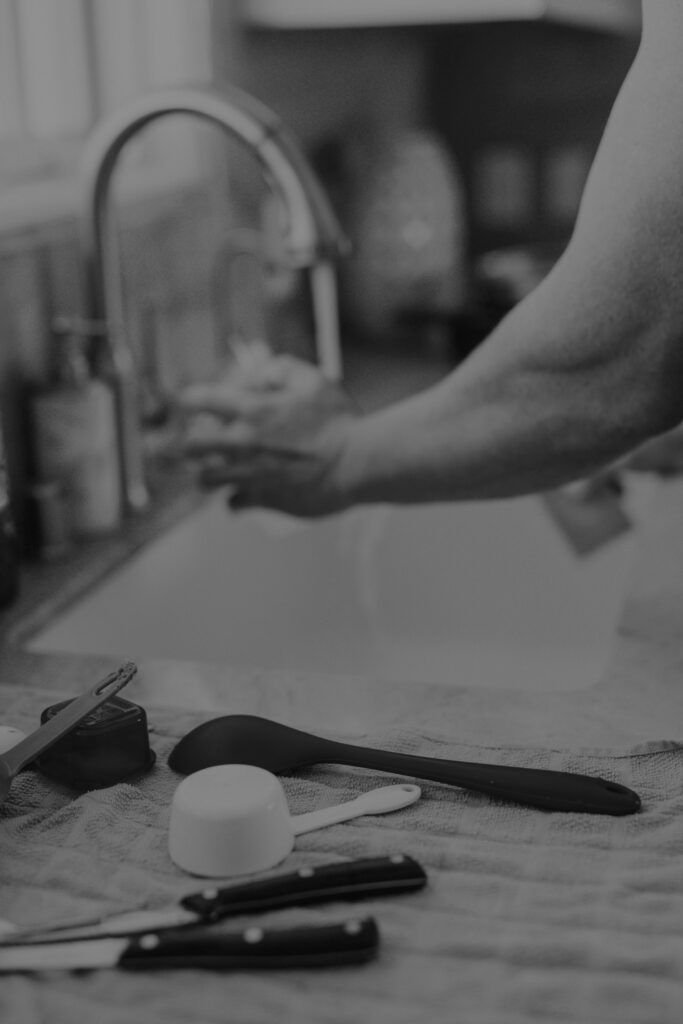 Blurred motion of hands washing dishes, representing the repetitive daily routine of burnout and autopilot
