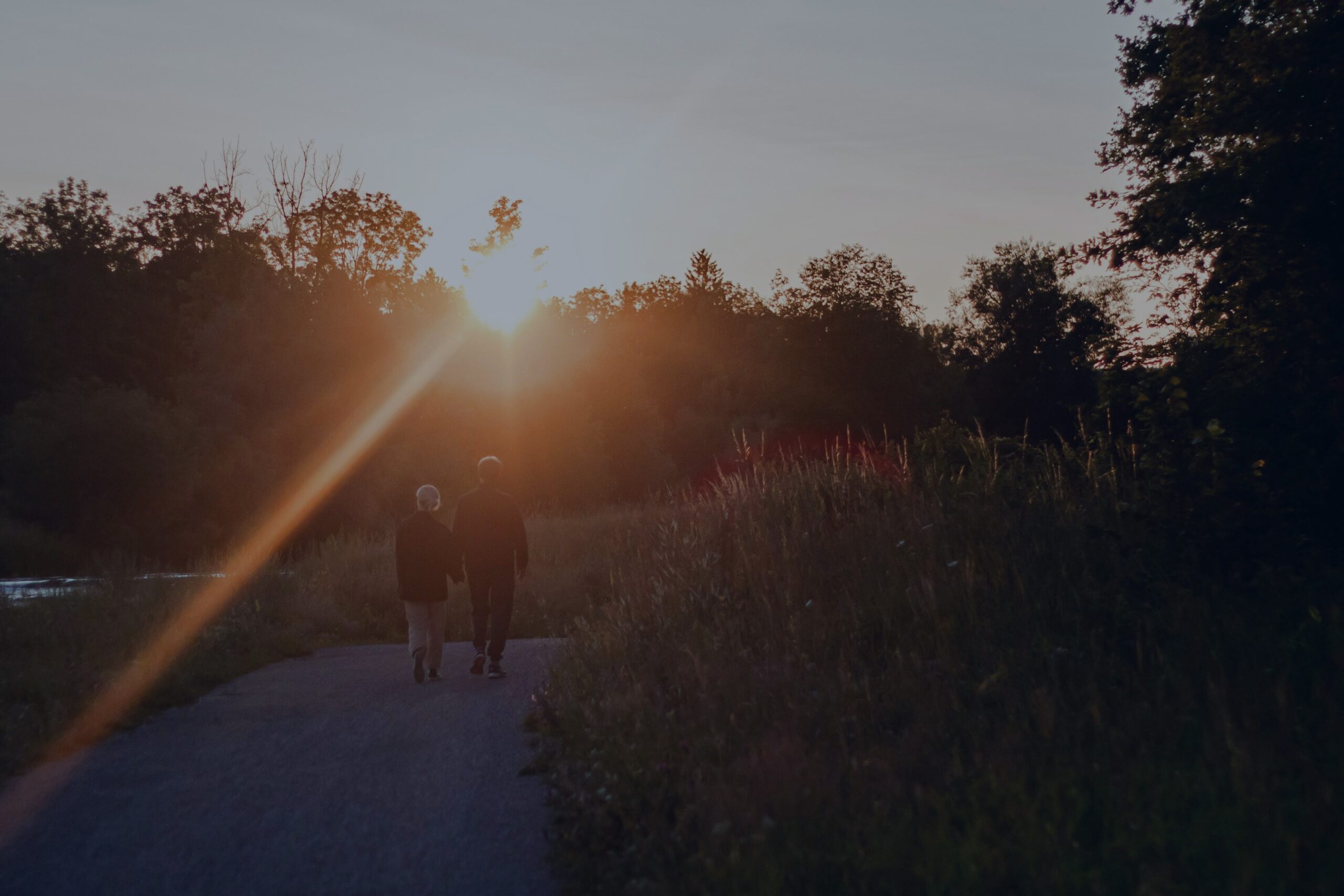 Two people walking together along a path at golden hour